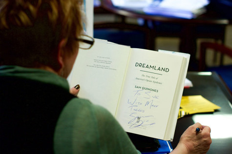 Provost Sue Ott Rowlands reviews her signed copy of "Dreamland." She has been coordinating Quinones' visit to campus since last summer. 