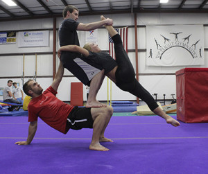 Photo by Maggie Pund NKU student Kirk Wallace practices Acro-yoga with fellow gymnasts at Top Flight Gymnastics. Every week at the gym, Wallace can be seen teaching or practicing with friends Andrew Goeeicke and Kayla Ferguson.