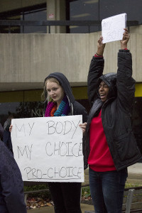 Students Tera Stadtmiller (left) and Megan Mayon (right) voice their opinions on the abortion-as-genocide display outside of the student union.