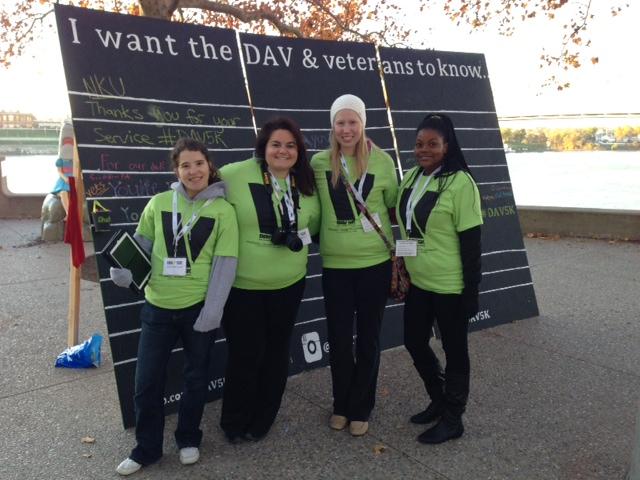 Students stand in front of display board at DAV 5K