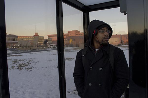 Patrick Pugh, EMB senior, waits outside in freezing temperatures for a bus. 