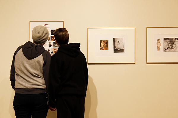 Two students view faculty member's photographs as part of the current art exhibition.