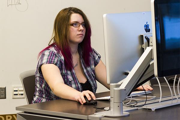 Emile Lubeck sits at a computer working on her web design work. Before web design Emile wanted to be a teacher.