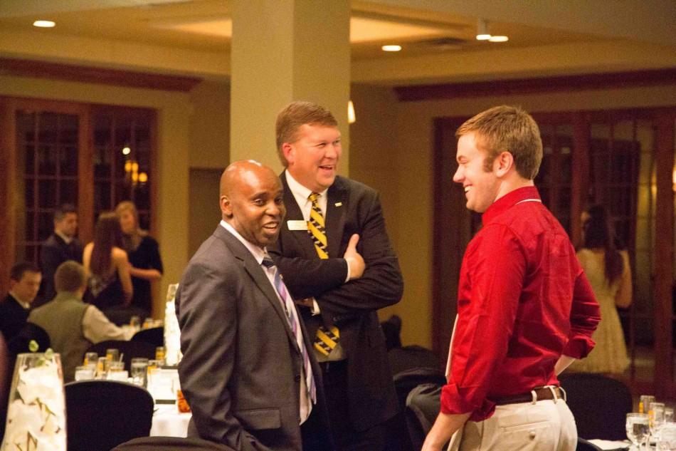 Dean Jeffrey Waple and Peter Gitau, vice president of Student Affairs talk with a member of the Homecoming 2014 court. 