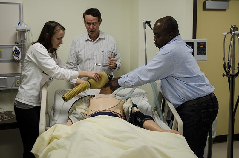 Allie Volpenhein (left), Bob Langenderfer (center), Atsou Koumi (right) practice resuscitation on a dummy. 