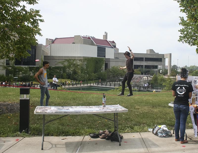 Junior Nick Canchola watches as his friend eases across a rope from tree to tree.