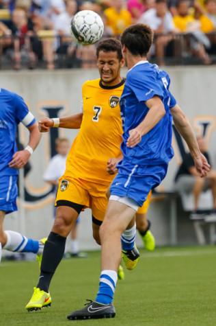 NKU Men's Soccer midfielder Alwin Komolong heads the ball towards the goal in the first half of NKU's home opener game vs UK. NKU tied University of Kentucky 0-0 Sunday, August 18, 2014 at NKU's Soccer Complex.