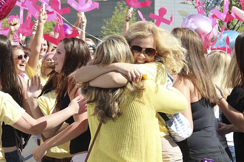 Two Delta Gammas hug after announcing their new sisters.