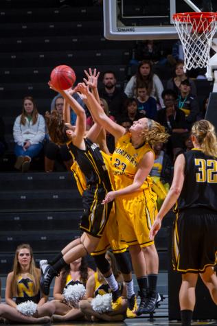 NKU women's basketball player Christine Roush (left) goes up for the layup against Kasey Uetrecht (23) during the scrimmage at Black and Gold Madness. NKU's 2014 Black and Gold Madness was held at the Bank of Kentucky Center on October 9, 2014 celebrating the start of the 2014-15 season.