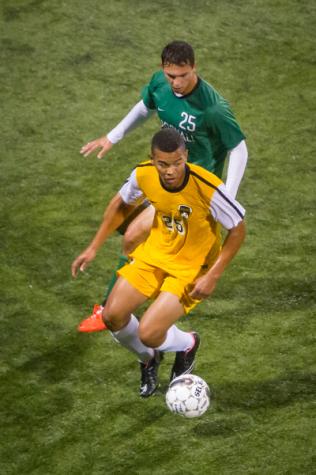 NKU soccer player Kobie Qualah dribble away from Marshal's Cory Shimensky in the first half of NKU's 2-1 loss against the Thundering Herd. NKU lost 2-1 to Marshall University Wednesday, Oct. 15, 2014 at NKU Soccer Stadium.