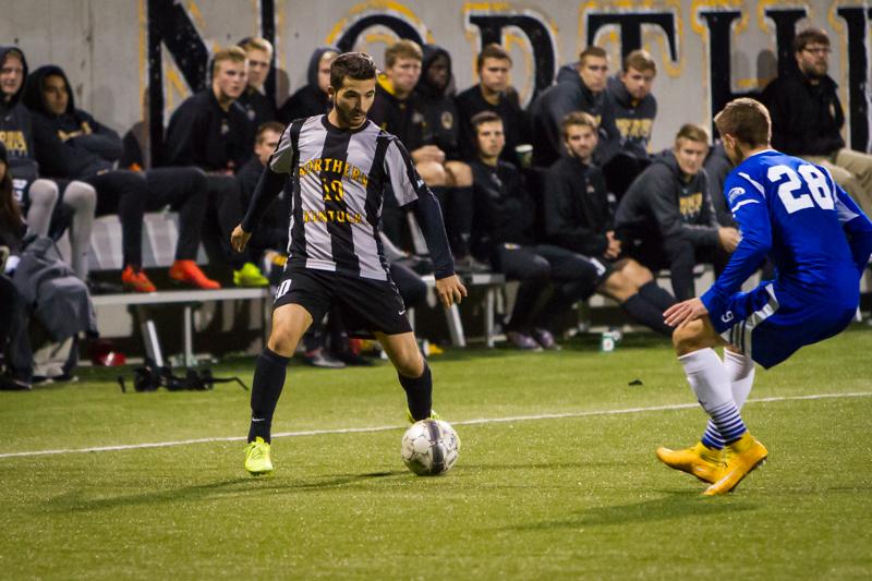 NKU player Diego Martinez dribbles against a defender in the second half of NKU's 2-0 win over UNC Asheville. NKU defeated UNC Asheville 2-0 on Oct. 22, 2014 at NKU Soccer Stadium.