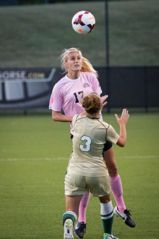 NKU player Aubrey Muench heads the ball over a defender in NKU's 1-0 loss to Jacksonville Friday night. NKU lost to Jacksonville 1-0 at NKU Soccer Stadium on Oct. 3, 2014.