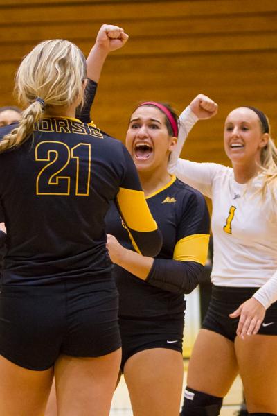 NKU's Lauren Hurley (center) celebrates after a scored point with Jayden Julian (left) and Mel Stewart (right). Lauren had 4 aces during NKU's 3-0 win against Jacksonville at Regents Hall on October 11, 2014.