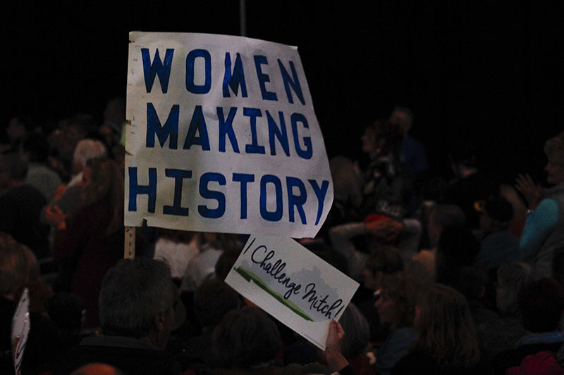 A woman waves a homemade sign at today's event. Women's issues were a topic highlighted in multiple of today's speeches.