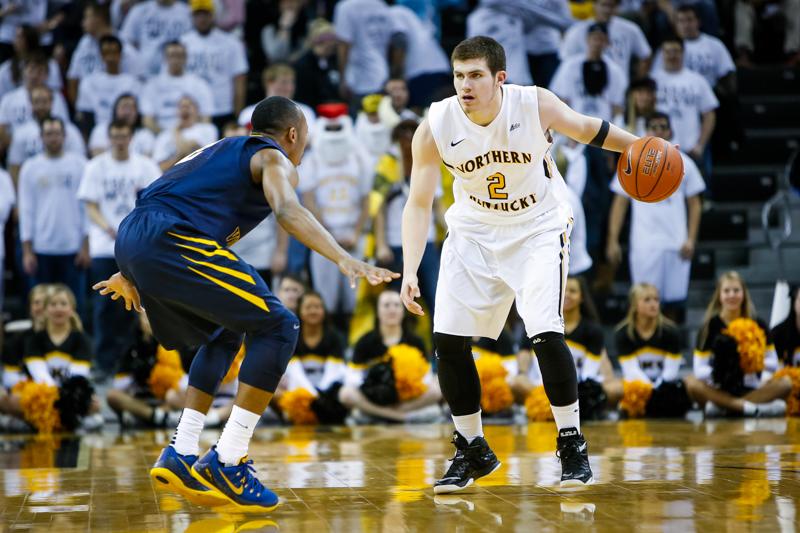 NKU mens basketball player Tayler Persons dribbles around a defender during the first half of NKUs 42-67 loss to West Virginia University. NKU was defeated by West Virginia University 42-67 at The Bank of Kentucky Center on Sunday, Dec. 7, 2014.