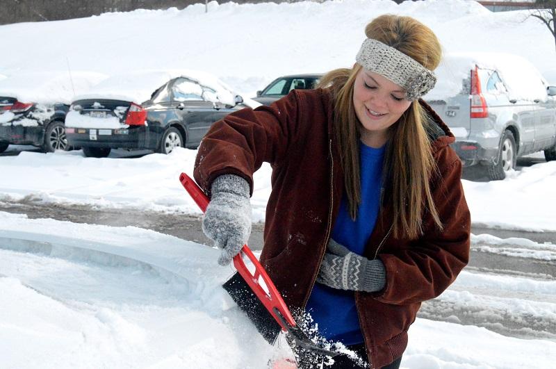 Freshman Diane Poe works to clear the snow off of her car this afternoon. NKU was closed Wednesday, Feb. 18 due to inclement weather.