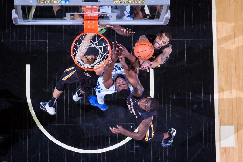 NKU guards Chad Jackson (top right), Tyler White (left) and center Jalen Billups (bottom right) struggle to rebound the ball against FGCUs Marc-Eddy Norelia (center) during NKUs 59-65 loss to FGCU. NKU lost to Florida Gulf Coast 59-65 at The Bank of Kentucky Center on Thursday, Feb. 12, 2015.