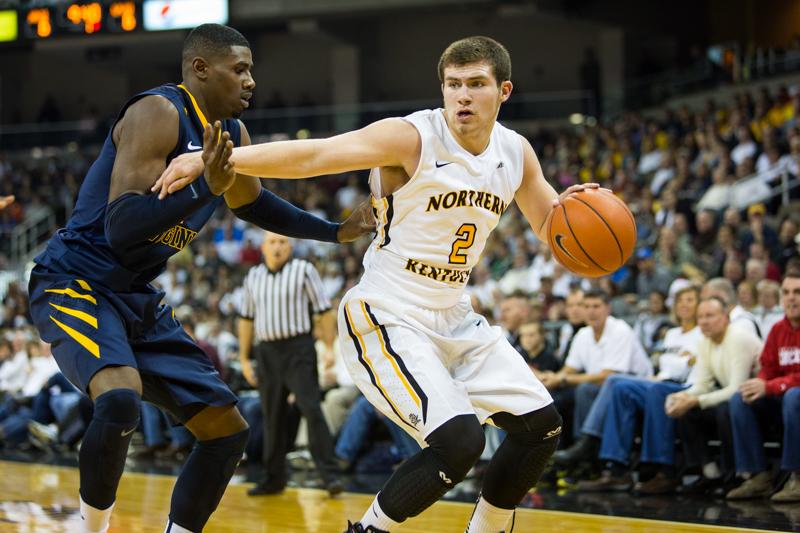 NKU guard Tayler Persons dribbles the ball while holding off a West Virginia University defender during NKUs loss to WVU.