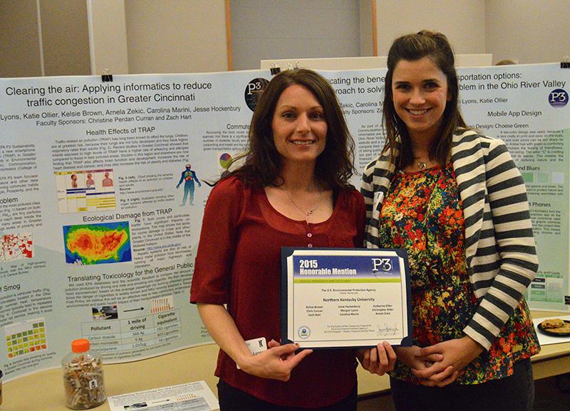 Morgan Lyons and Arnela Zekic hold their honorable mention award in front of their poster presentation at Celebration on April 15. 