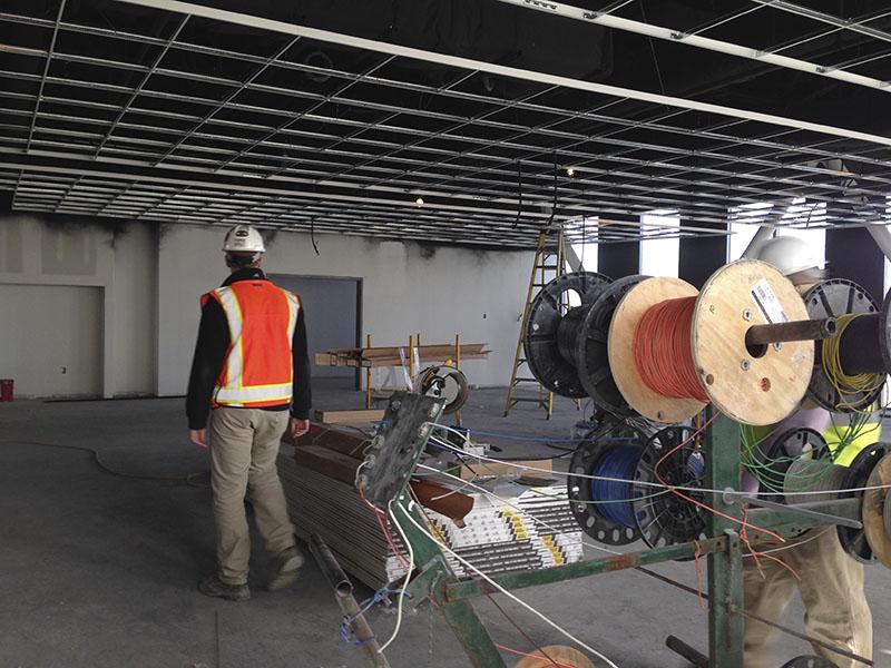 Project Manager JD Barnes leads the way through what will be a spinning room. SGA toured the site March 30.