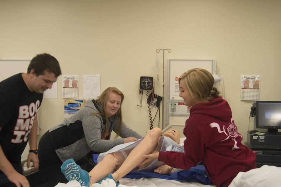 First-year nursing students (left to right) Anthony Roberts, Allison Fangman and Katie Golfman transfer a mannequin in a skills lab. 