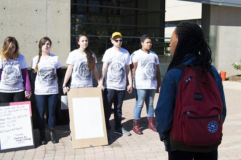 Students stand during the silent protest bringing awareness to school shootings and gun violence. The protest was organized by Students for Social Change.