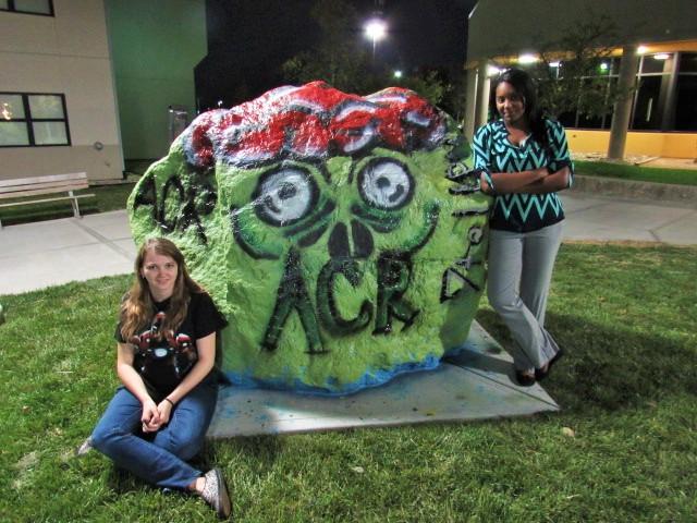 The VP and President of ACR, Brandy Brawner (left) and Dana Jetter (right) paint the spirit rock in front of Norse Commons hoping to get students excited for Callahans Haunted House, coming up on Oct. 29. 