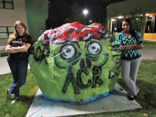 The VP of ACR, Brandy Brawner (left) and President, Dana Jetter (right) paint the spirit rock in front of Norse Commons advertising Callahan's Haunted House on Oct. 29. 