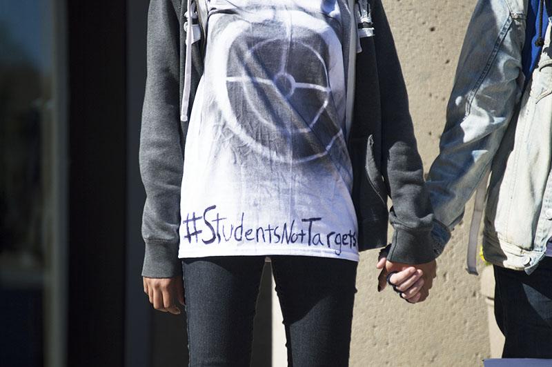 Students stand during the silent protest bringing awareness to school shootings and gun violence. The protest was organized by Students for Social Change.