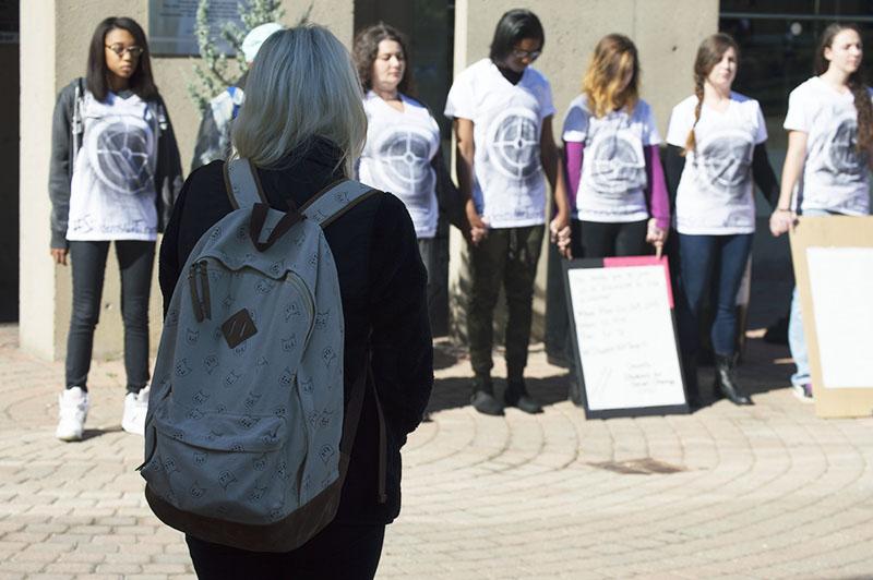 Students stand during the silent protest bringing awareness to school shootings and gun violence. The protest was organized by Students for Social Change.