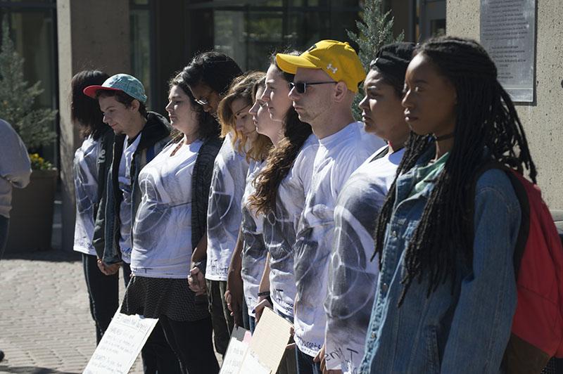 Students stand during the silent protest bringing awareness to school shootings and gun violence. The protest was organized by Students for Social Change.