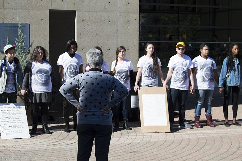 Students stand during the silent protest bringing awareness to school shootings and gun violence. The protest was organized by Students for Social Change.