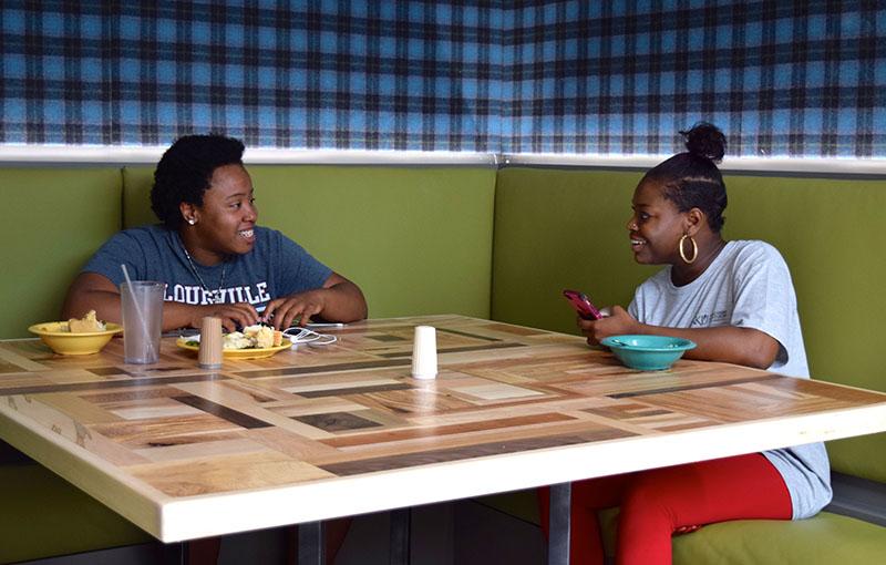 Two students socialize over lunch in the new Callahan Bistro.