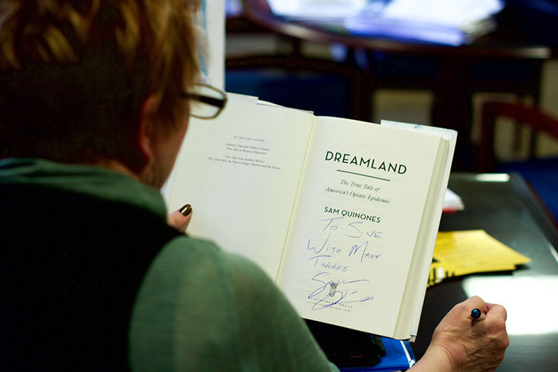 Provost Sue Ott Rowlands reviews her signed copy of Dreamland. She has been coordinating Quinones visit to campus since last summer. 