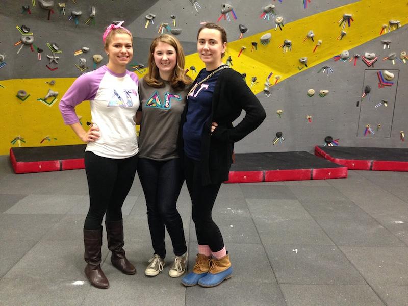 Alli Zembrodt(left) and her friends gather their strength to climb the rock wall, part of the homecoming festival. 
