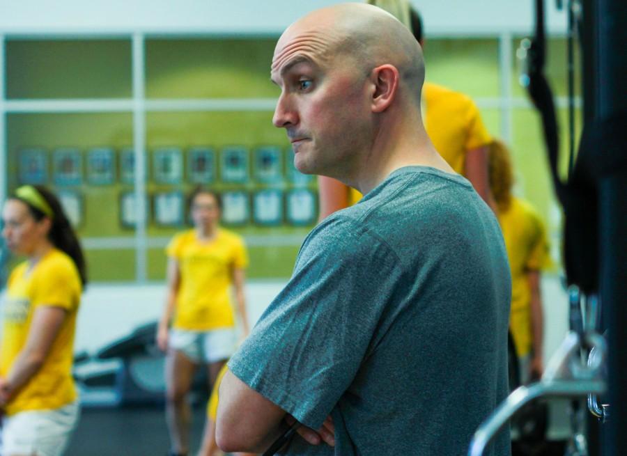 NKU strength and conditioning coach Brian Boos oversees athletes lifting in the weight room.