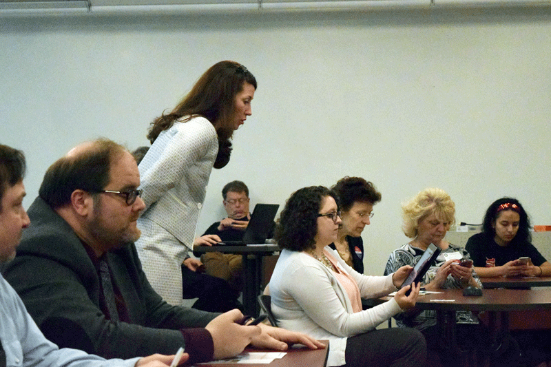 Kentucky Secretary of State Alison Lundergan Grimes (standing) watches over an audience member as she tries out Kentuckys new online voter registration system.