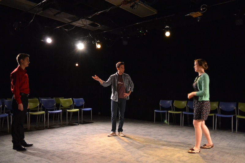 Colin Kissel (John), introducing his two love interests George Ivan (Man) and Hallie Hargus (Woman) during a rehearsal for "Cock".