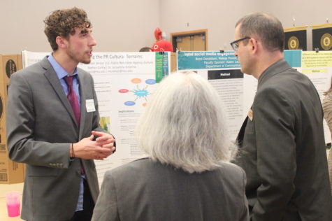 Nathan Garbig discusses his poster at the Celebration Festival with Zach Hart, co-chair of the event.