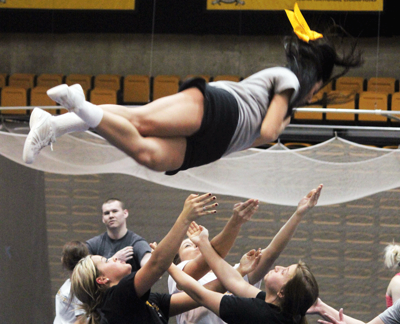 Megan McDonough spins through the air while Zana Harman, Mandy Shephard and Morgan Harper prepare to catch her.