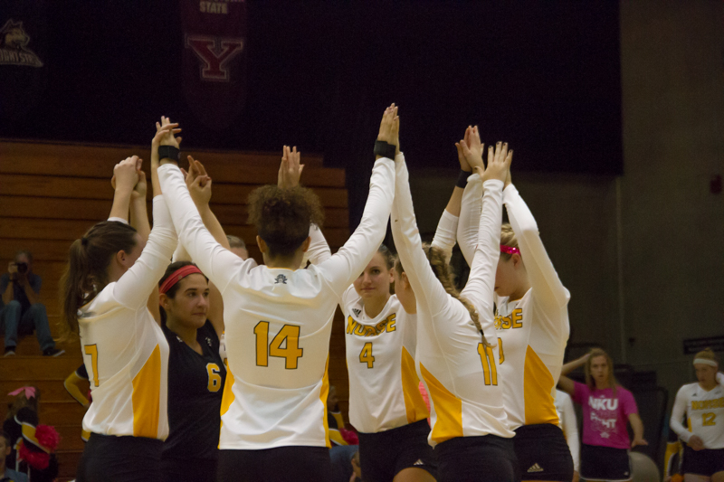 The Norse volleyball team raises their hands in celebration after scoring a point. Creamer (14) won Horizon League Offensive Player of the Week while Lauren Hurley (6) won Defensive Player of the Week.