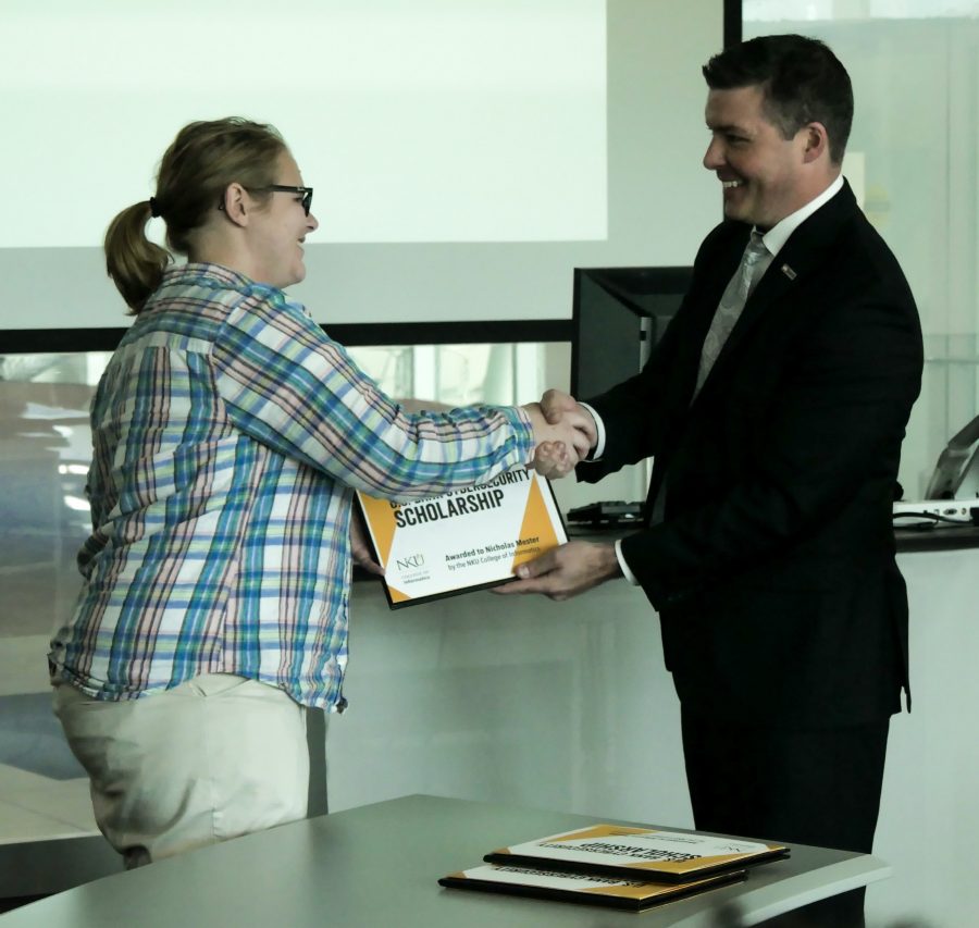 Allyson Frame (left) receives her scholarship from Jason Witty, US Bank executive vice president and chief information security officer.