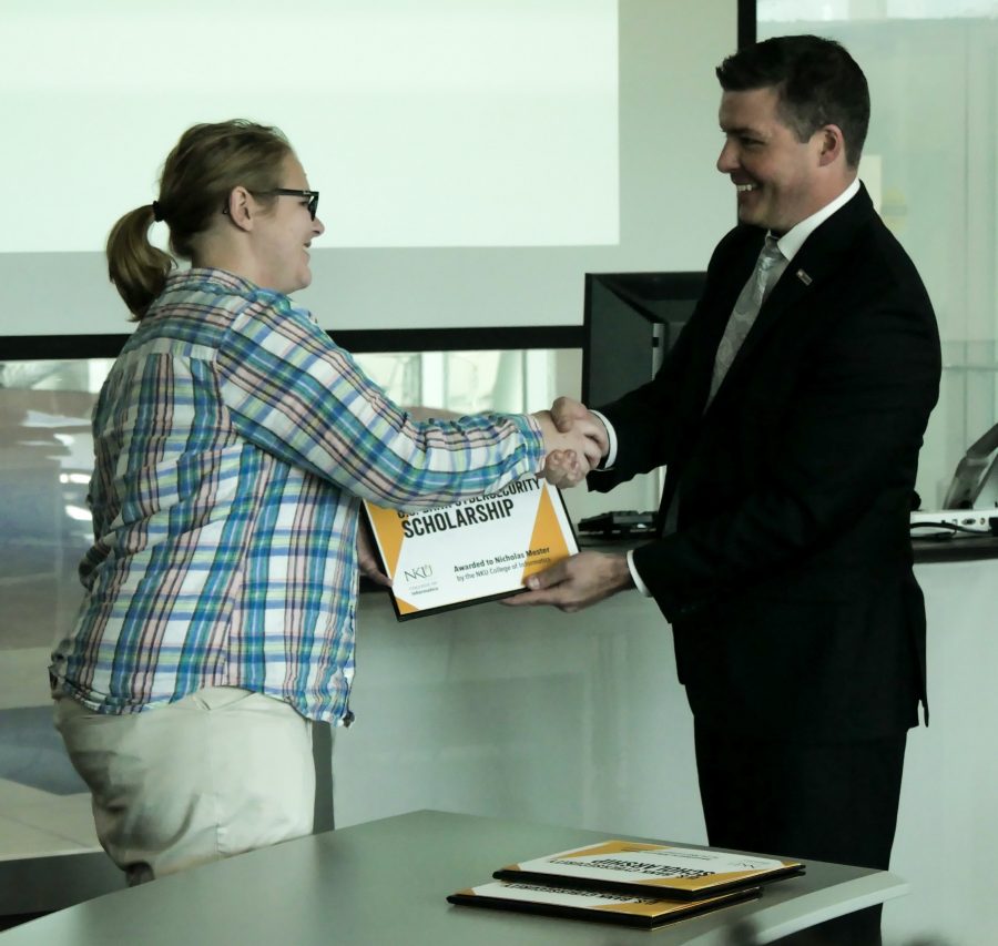 Allyson Frame (left) receives her scholarship from Jason Witty, US Bank executive vice president and chief information security officer.