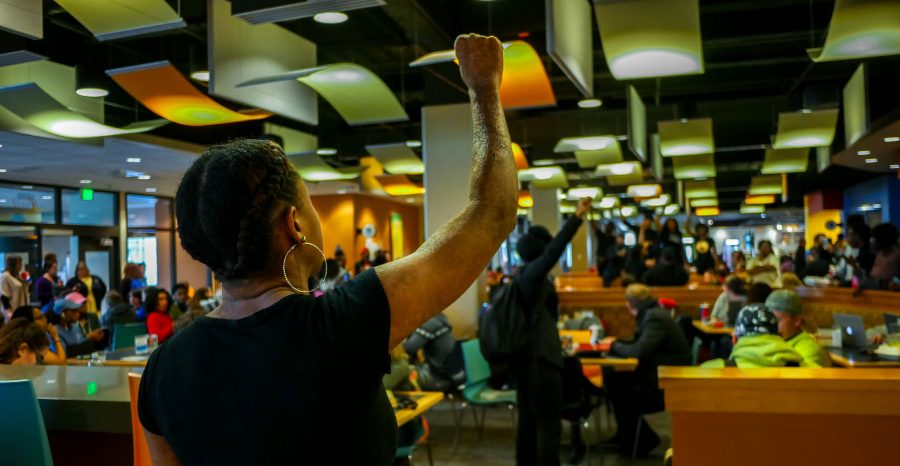 Tekiuh Hutton raises her fist in solidarity with The Unaddressed. Several students performed a spoken word demonstration in the SU.  