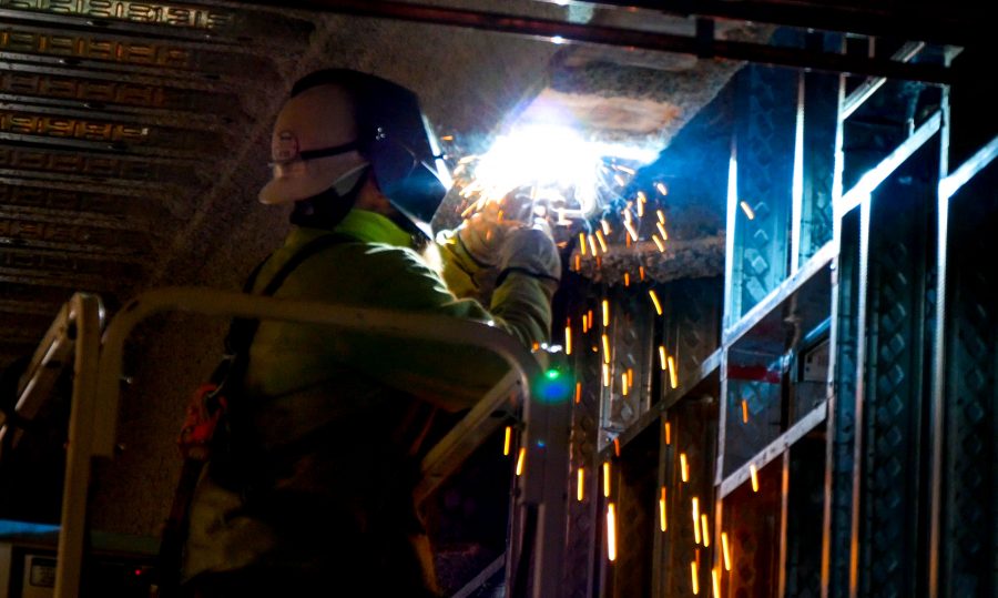 A worker welds to the steel framing of the HIC building.