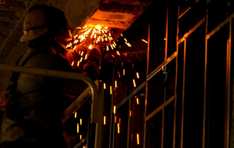 A worker welds to the steel framing of the HIC building.