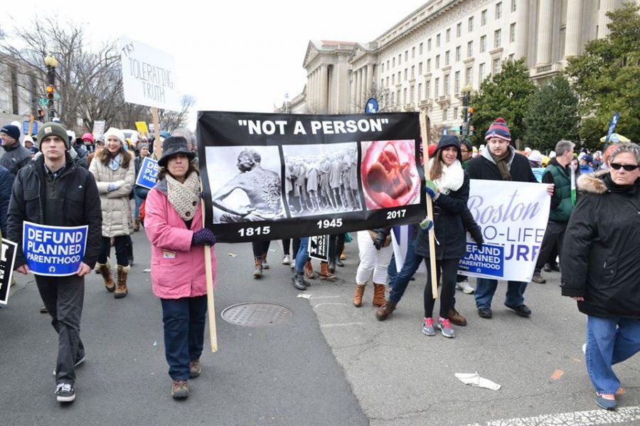 Protestors hold signs. The March took place in Washington, D.C.