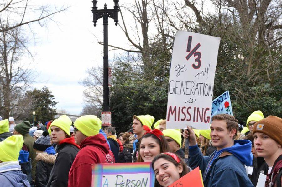 1/3 of my generation is missing. Marchers show signs to support their movement.
