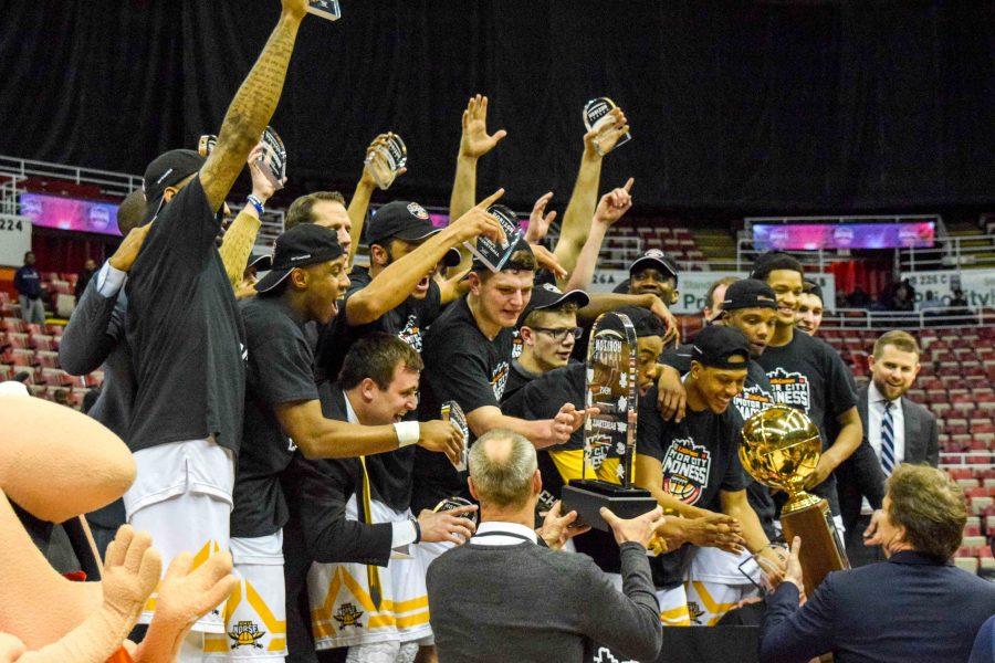 NKU AD Ken Bothof presents the Norse the Horizon League tournament championship trophy.