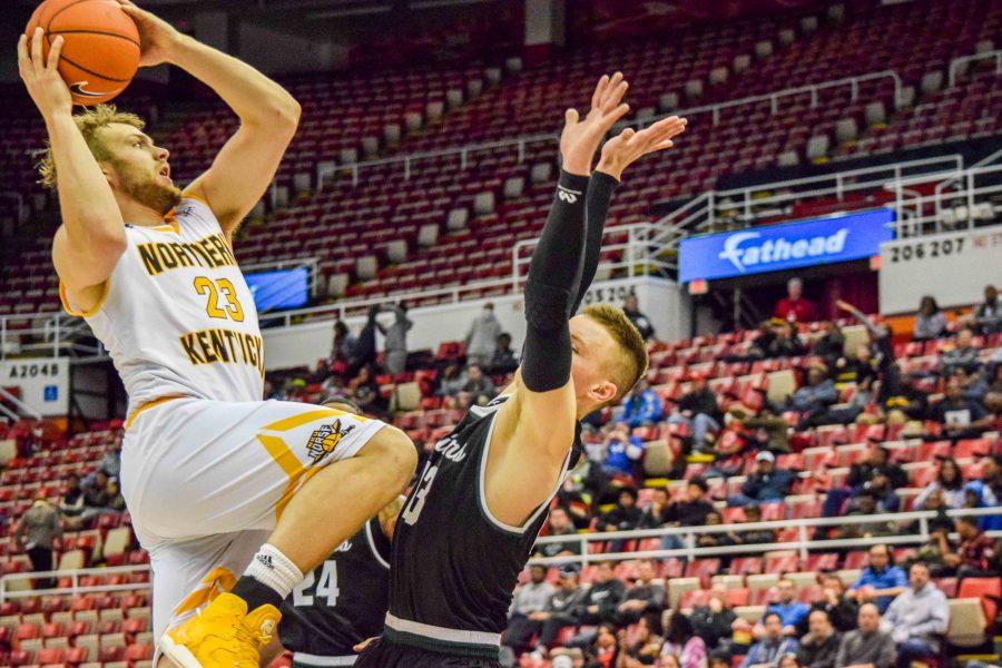 NKU's Carson Williams (23) goes up over Grant Benzinger (13) during Sunday's Horizon League quarterfinal game at Joe Louis Arena.